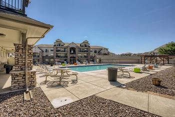 A pool area with a table and chairs and aat Fox Run Lofts Apartments, Englewood CO